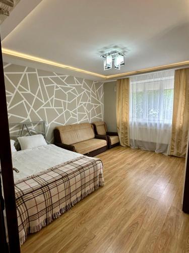 una camera da letto con un letto e un divano di HomeSweetHome a Chişinău