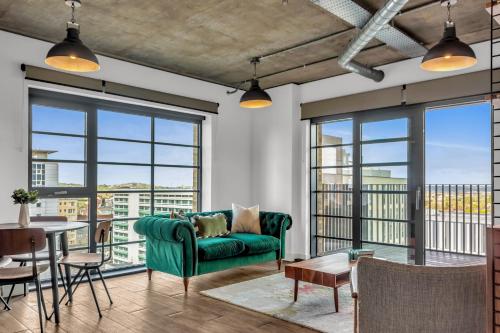a living room with a green couch and a table at MySquare State-of-the-Art 1 bedroom Apartments near Wembley Park in London