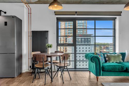 a living room with a green couch and a table at MySquare State-of-the-Art 1 bedroom Apartments near Wembley Park in London