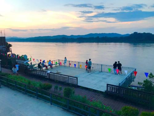 a group of people standing on a dock near the water at บ้านสายน้ำ ติดแม่น้ำโขง in Chiang Khan