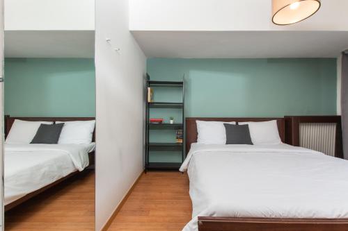 twee bedden naast elkaar in een slaapkamer bij Houseloft Cosmopolitan Comfort in Thessaloniki