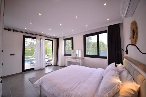 a bedroom with a large white bed and windows at Villa Matisse in Belen