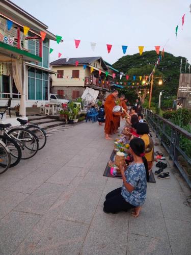 a group of people sitting around a table with food at บ้านสายน้ำ ติดแม่น้ำโขง in Chiang Khan