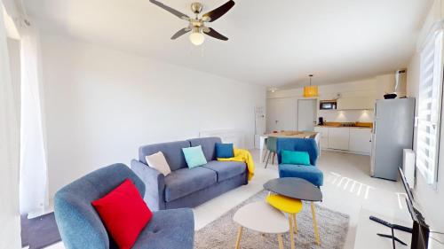 - un salon avec un canapé bleu et des oreillers colorés dans l'établissement La Suite Oceane, à Givrand