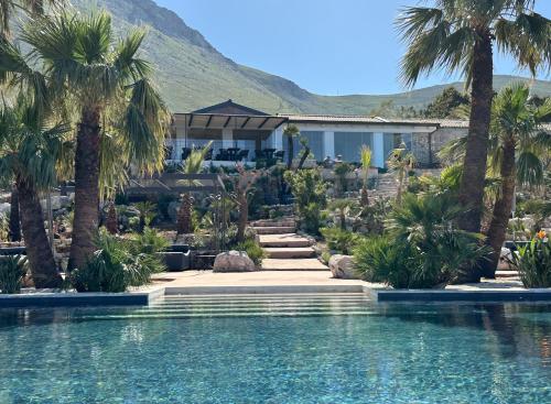 a resort with palm trees and a swimming pool at Baglio La Porta by Geocharme in San Vito lo Capo