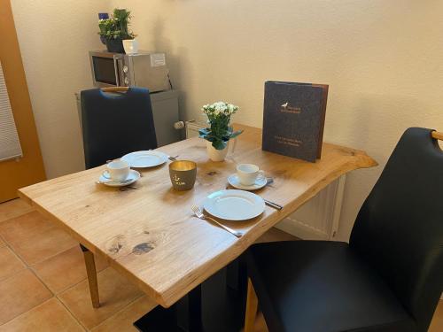 a wooden table with two cups and plates on it at Haus Deutsche Bucht in Borkum