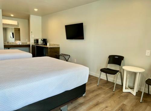 a hotel room with two beds and a table and a kitchen at Lakeside Motel, Cabins and RV in Kingston