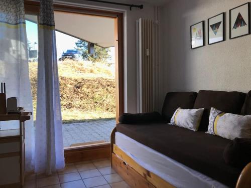 - un salon avec un canapé en face d'une fenêtre dans l'établissement 2 pièces 4-6 personnes rénové avec parking couvert, 100m des pistes, à Montvalezan