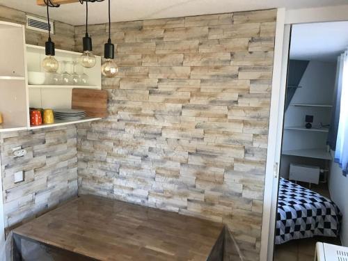 un mur en fausse pierre dans une cuisine avec une table dans l'établissement 2 pièces 4-6 personnes rénové avec parking couvert, 100m des pistes, à Montvalezan
