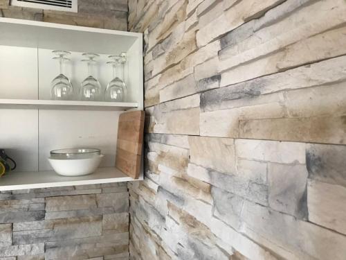 - un mur en pierre dans une cuisine avec un comptoir dans l'établissement 2 pièces 4-6 personnes rénové avec parking couvert, 100m des pistes, à Montvalezan