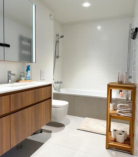 a bathroom with a sink and a toilet and a tub at Luxury studio with balcony in Reykjavík