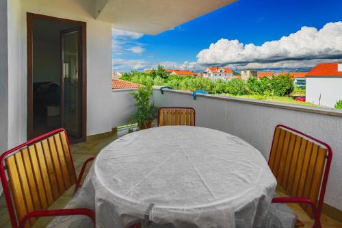 a table and chairs on a balcony with a view at Holiday apartment Kali - Ugljan island in Kali