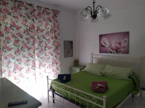 Un dormitorio con una cama verde y una ventana en Cerroni's corner CISE 29636, en Roma
