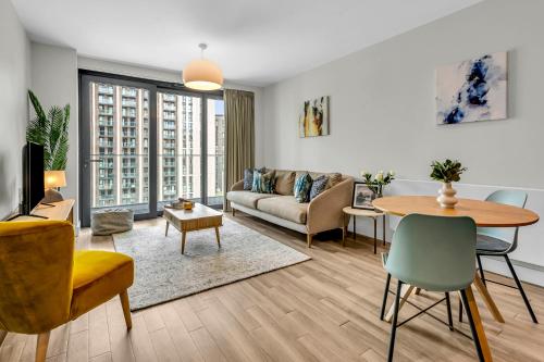 a living room with a couch and a table at State-of-the-Art 1 bedroom Apartments near Wembley Park in London