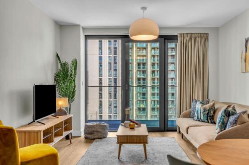 a living room with a couch and a tv at MySquare State-of-the-Art 1 bedroom Apartments near Wembley Park in London