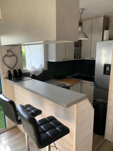 - une cuisine avec un comptoir et quelques chaises dans l'établissement Appartement cosy, au Croisic