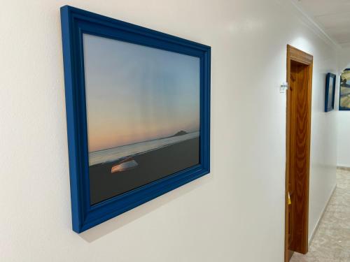 a blue picture frame hanging on a wall at Hostal Juan Carlos in Carboneras