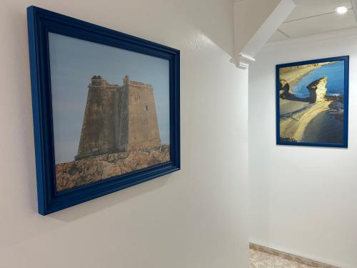 a framed picture of a tower on a wall at Hostal Juan Carlos in Carboneras