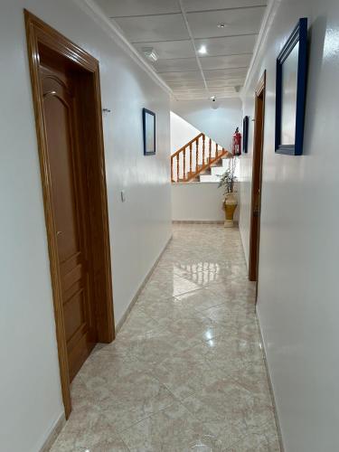 a hallway with a door and a staircase in a house at Hostal Juan Carlos in Carboneras