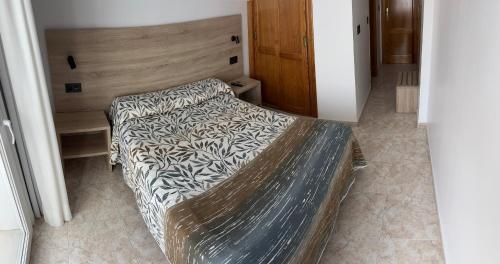 a bedroom with a bed with a wooden head board at Hostal Juan Carlos in Carboneras