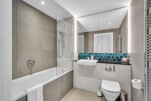 a bathroom with a toilet and a sink and a tub at MySquare State-of-the-Art 1 bedroom Apartments near Wembley Park in London