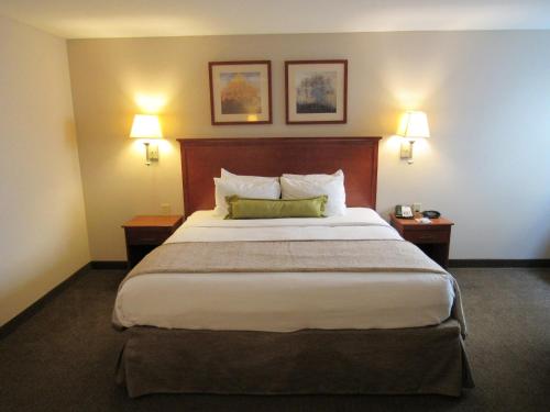 a hotel room with a large bed with two lamps at Candlewood Suites Murfreesboro by IHG in Murfreesboro