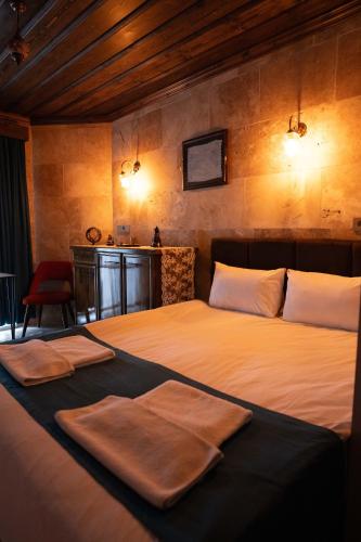 a bedroom with a large bed with two towels on it at Grand Uchisar Hotel in Uchisar