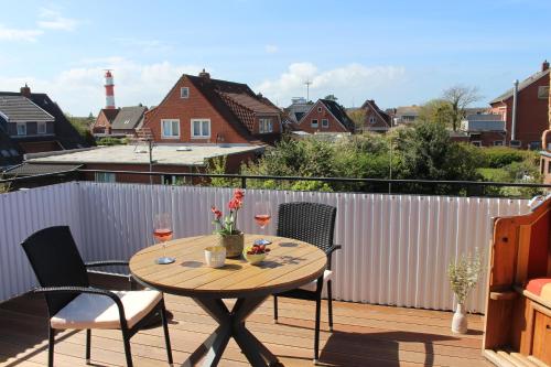 a table on a balcony with two glasses of wine at Haus Deutsche Bucht in Borkum