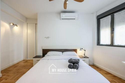a white bedroom with a bed and a window at MyHouseSpain - Tranquilo piso cerca de Sol in Madrid