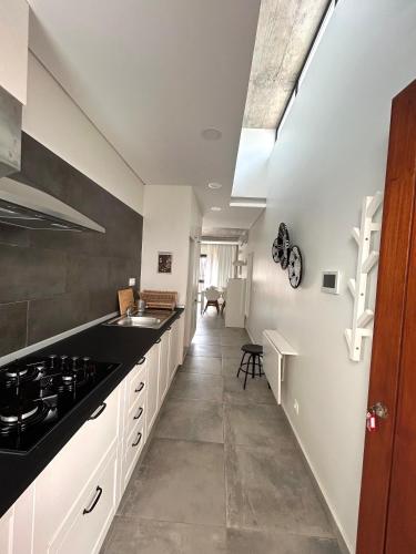 a kitchen with white cabinets and a black counter top at Papaya Apartments Sal Island in Santa Maria