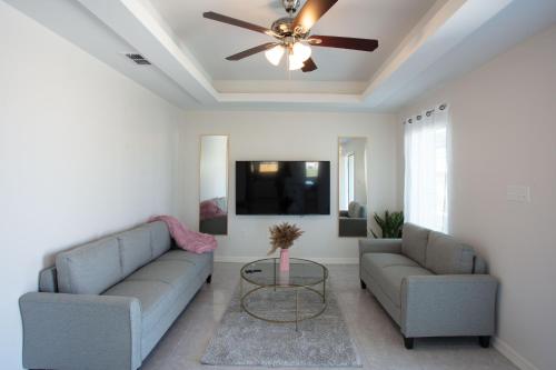 a living room with two couches and a ceiling fan at Luxurious & Comfy near SpaceX Starbase with Desks in Brownsville