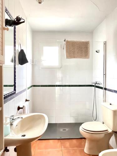 a white bathroom with a sink and a toilet at Casa Rural Pernales II in Ruidera