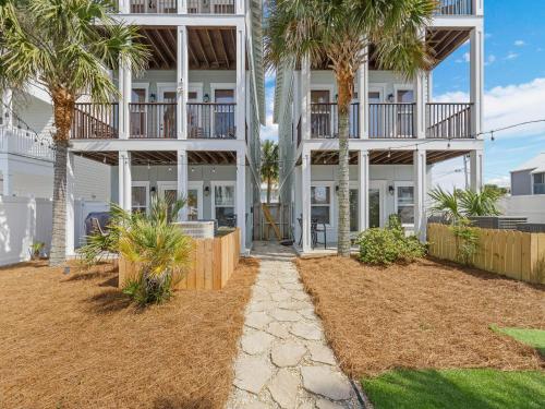 a building with palm trees in front of it at Salty Beach in Panama City Beach