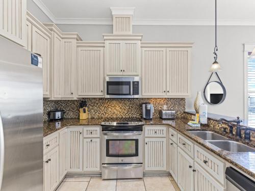 a kitchen with white cabinets and a stainless steel appliance at Salty Beach in Panama City Beach