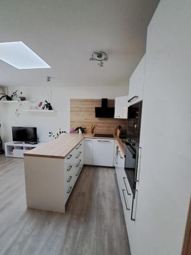 a kitchen with white cabinets and a white counter top at Moderný 2 izbový dom so záhradou a terasou blízko Bratislavy in Slovenský Grob