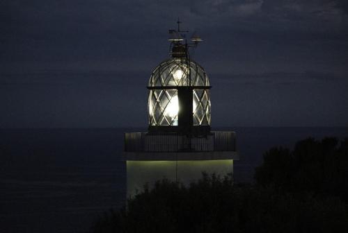 a lighthouse with a light in it at night at El Far Hotel Restaurant in Llafranc