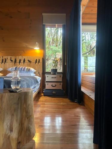 a bedroom with a bed and a large window at Vallée Cabanas in Urubici
