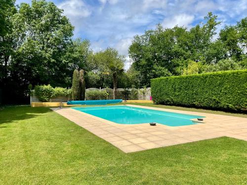 - une piscine dans une cour à côté d'une haie dans l'établissement LE CLOS DU BENESTAR, à Mauvezin-dʼArmagnac