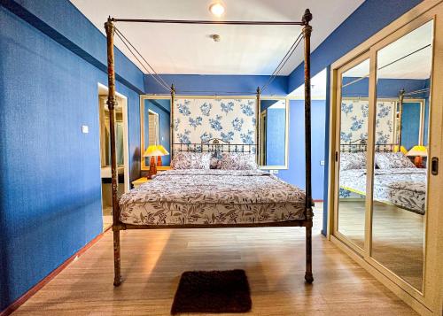 um quarto com uma cama de dossel e paredes azuis em Trillium Apartment - Cozy and Bright Downtown Surabaya by Le Ciel Hospitality em Surabaya