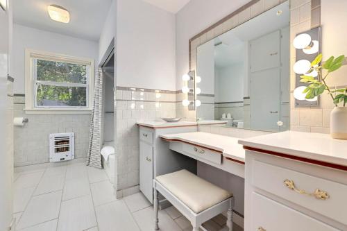 a white bathroom with a sink and a mirror at Fayetteville Flashback 2 Mi to Downtown in Fayetteville