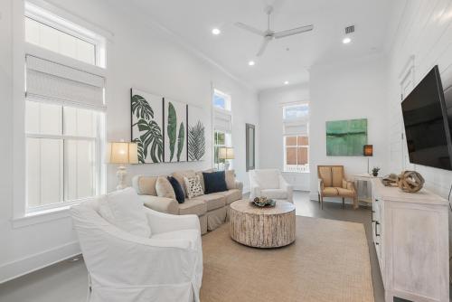 sala de estar con muebles blancos y TV en Beach Village Resort By Liquid Life, en Gulf Shores