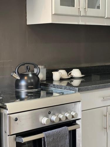 a tea kettle sitting on top of a stove in a kitchen at Protea on Main Valley of 1000 hills in Drummond