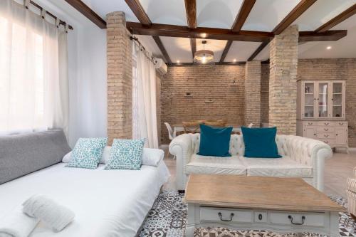 ein Wohnzimmer mit weißen Möbeln und blauen Kissen in der Unterkunft My Loft 4 You Sorolla in Valencia