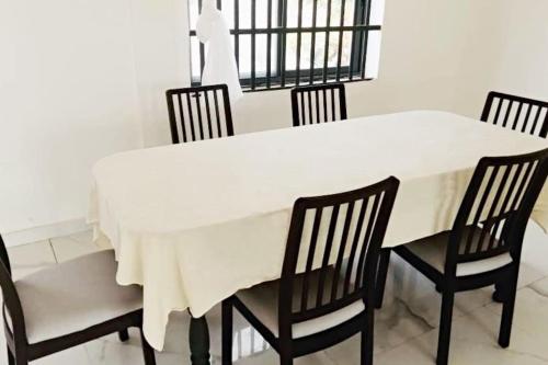 une table à manger avec des chaises et une nappe blanche dans l'établissement Villa luxueuse - front de mer - vue sur la mer, à Cotonou