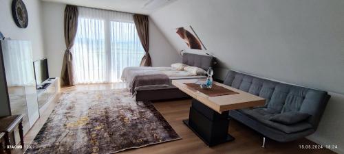 ein Schlafzimmer mit einem Bett, einem Sofa und einem Tisch in der Unterkunft Schicke Ferien Wohnung mit tollem Ausblick in Schwarzwald. in Villingen-Schwenningen