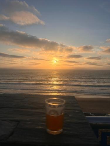 a glass of beer sitting on a table on the beach at Villa Naoual in Moulay Bousselham