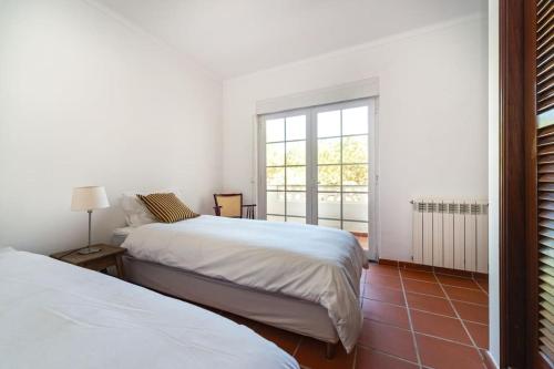 a bedroom with two beds and a window at Praia del Rey Golf & Beach Resort - T3 in Amoreira