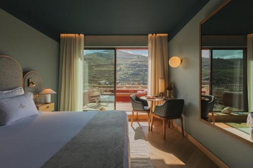 Torel Quinta da Vacaria - Douro Valley في بيسو دا ريجوا: غرفة نوم بسرير وطاولة مع كراسي