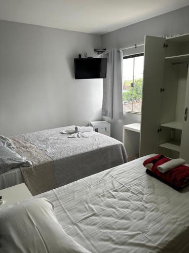 a bedroom with two beds and a window at Hotel Vitrine in Goiânia