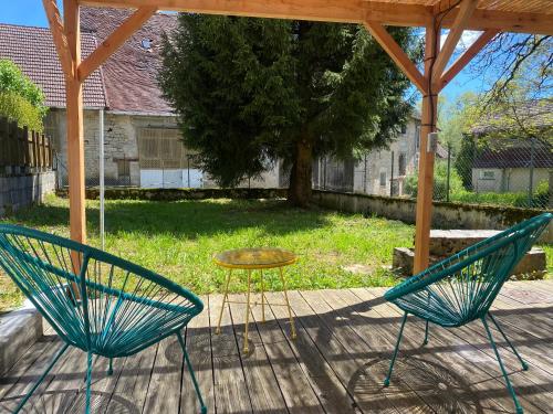 two chairs and a table on a patio at Gite du sapin - Lac de Vouglans in Orgelet